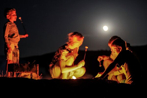 Туристы во время полного лунного затмения над мысом Меганом в Крыму