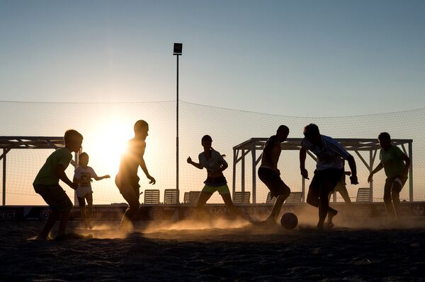 Отдыхающие на пляже играют в футбол в поселке Оленевка, Крым
