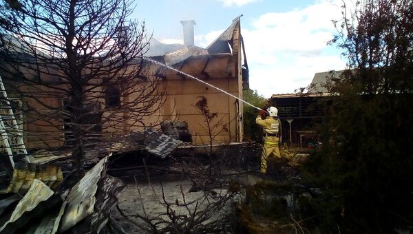 Спасатель во время тушения пожара в здании бани в Кировском районе