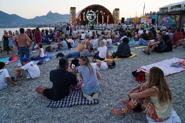Люди расположились на пляже недалеко от главной сцены международного музыкального фестиваля Koktebel Jazz Party. 25 августа 2018