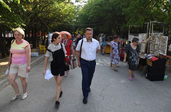 Торговые точки на набережной в Коктебеле. На фото: замначальника Службы капитального строительства РК Роман Цинцевич и корреспондент РИА Новости Крым Алина Богадица Торговые точки на набережной в Коктебеле. На фото: замначальника Службы капитального строительства РК Роман Цинцевич и корреспондент РИА Новости Крым Алина Богадица
