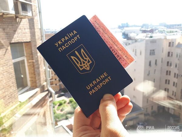 Гражданин Украины держит паспорт и патент на работу в РФ Гражданин Украины держит паспорт и патент на работу в РФ