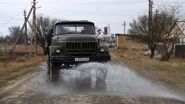 Машина поливает улицы в поселке Перекоп под Армянском