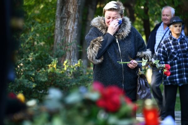 Люди несут цветы к народному мемориалу в Керчи в память о погибших в Керченском политехническом колледже, в котором произошли взрыв и стрельба
