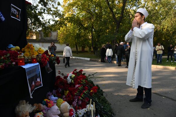 Мужчина у народного мемориала рядом с Керченским политехническим колледжем, в котором произошли взрыв и стрельба