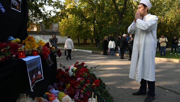 Мужчина у народного мемориала рядом с Керченским политехническим колледжем, в котором произошли взрыв и стрельба