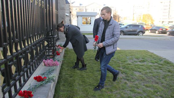 Люди возлагают цветы к посольству РФ в Минске в память о жертвах трагедии в Керчи