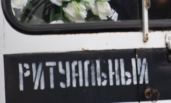 Мужчина в автомобиле ритуальной службы во время церемонии прощания с погибшими при нападении на Керченский политехнический колледж
