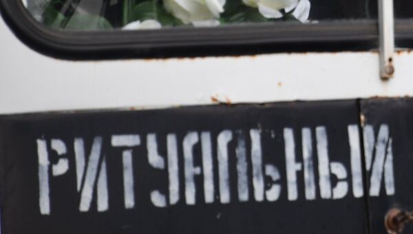 Мужчина в автомобиле ритуальной службы во время церемонии прощания с погибшими при нападении на Керченский политехнический колледж