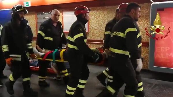 Сотрудники Службы гражданской защиты Италии несут на носилках одного из пострадавших при обрушении эскалатора на станции метро Repubblica в Риме