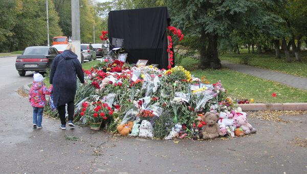 Люди несут цветы к импровизированному мемориалу возле Керченского политехнического колледжа