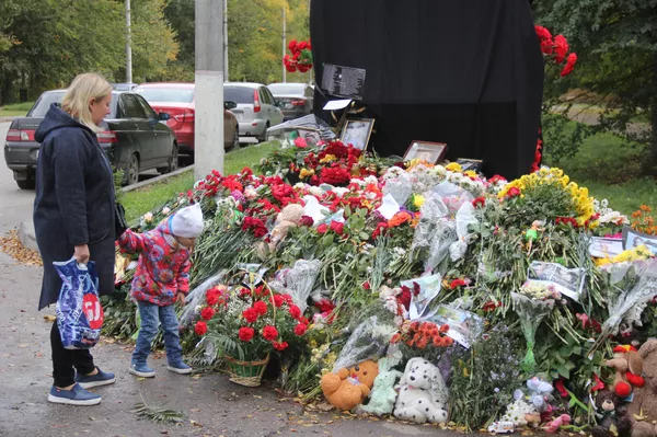 Женщина с ребенком возле народного мемориала в память о погибших в Керченском политехническом колледже Женщина с ребенком возле народного мемориала в память о погибших в Керченском политехническом колледже