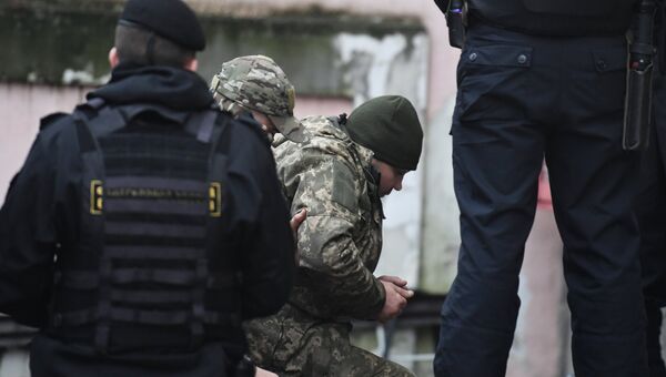 Один из задержанных моряков с кораблей ВМС Украины Бердянск, Никополь и Яны Капу (слева) доставлен в Киевский районный суд Симферополя. 27 ноября 2018
