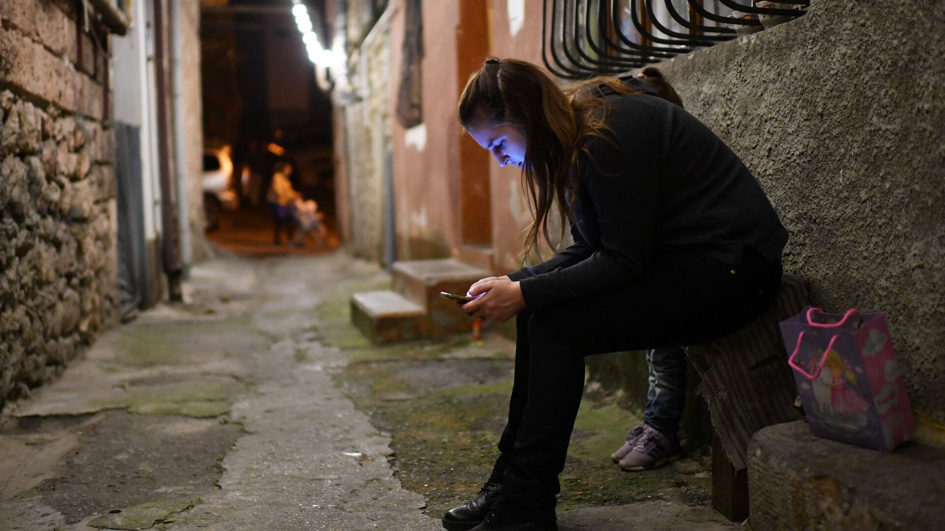 Девушка с мобильным телефоном в одном из переулков Ялты - РИА Новости, 1920, 15.01.2021