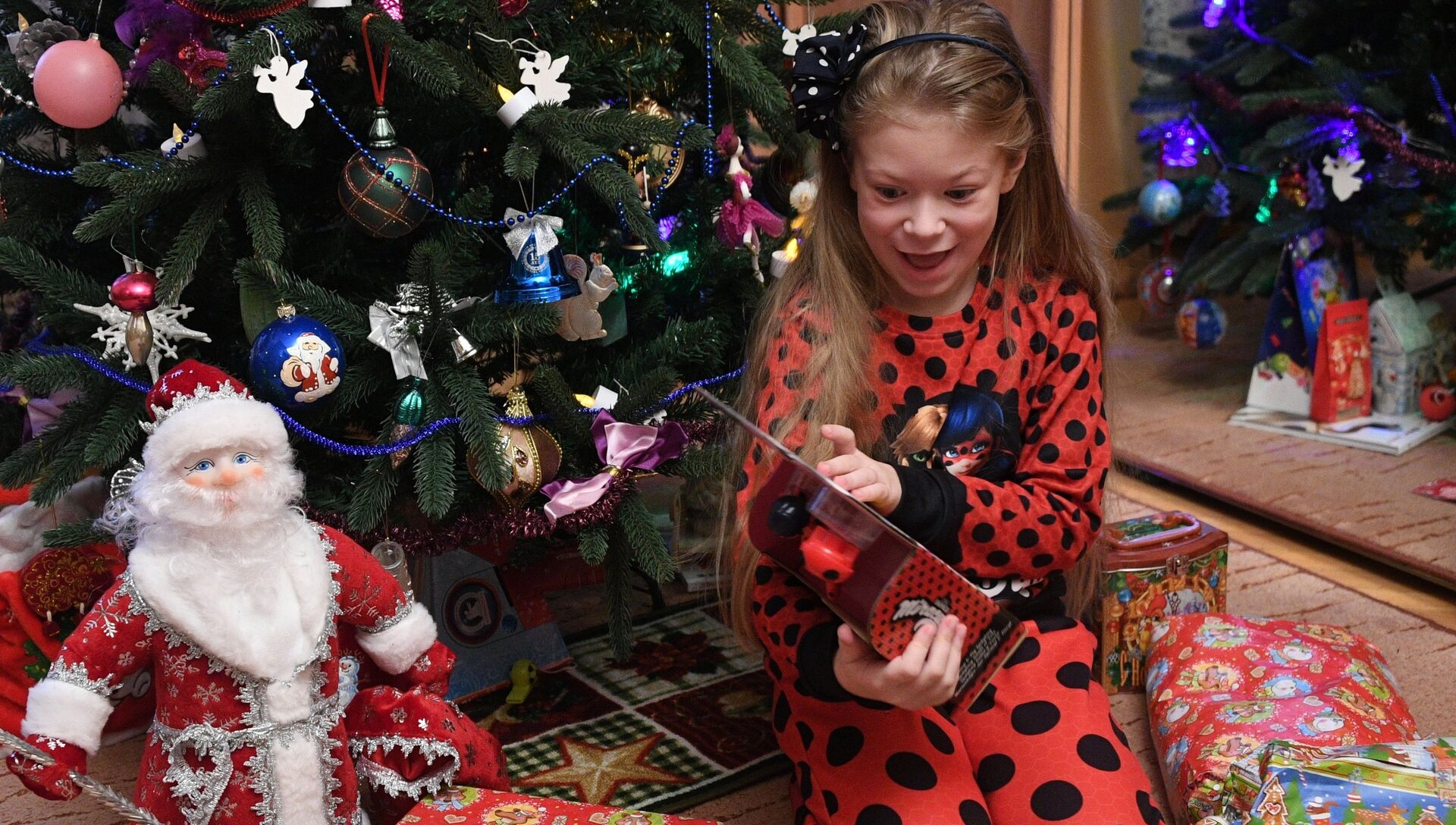 Девочка получает подарки во время празднования Нового года. Архивное фото - РИА Новости, 1920, 02.12.2020