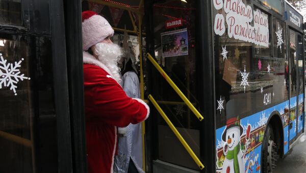 Дед Мороз зазывает пассажиров в новогодний троллейбус в Симферополе