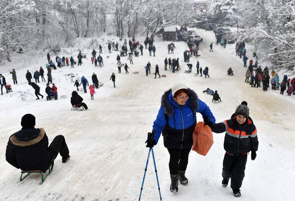 Люди катаются с горки на Ангарском перевале в Крыму