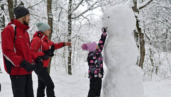 Семья с ребенком лепят снеговика во время отдыха на Ангарском перевале в Крыму