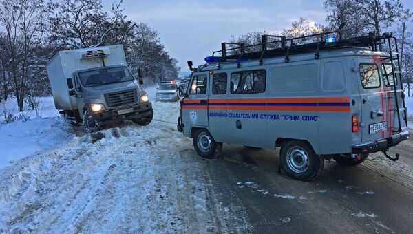 Сотрудники МЧС вытаскивают из снежного заноса в Кировском районе Крыма автомобиль ГАЗ Соболь