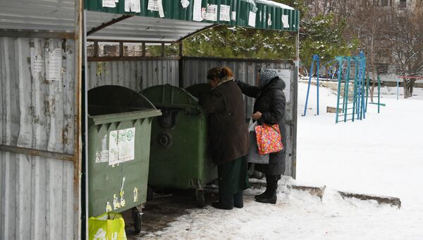  Женщина роется в мусорных контейнерах в Симферополе