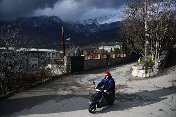 Мужчина едет на мопеде в Гурзуфе в Крыму