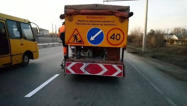 Сотрудники Крымавтодора наносят разметку на Евпаторийском шоссе