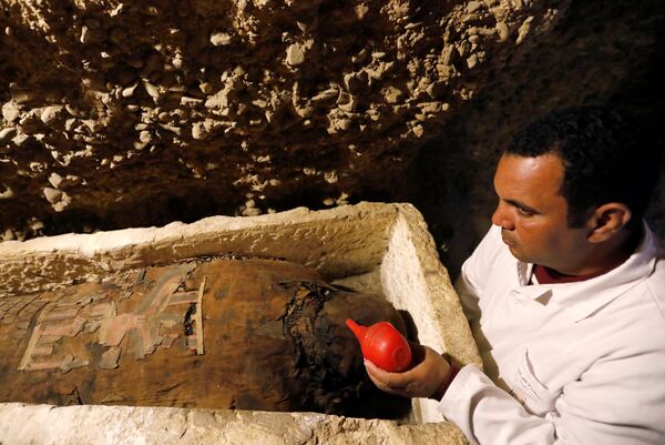 Археолог рядом с гробницей на презентации недавно открытого древнего кладбища в районе Туна эль-Габаль
