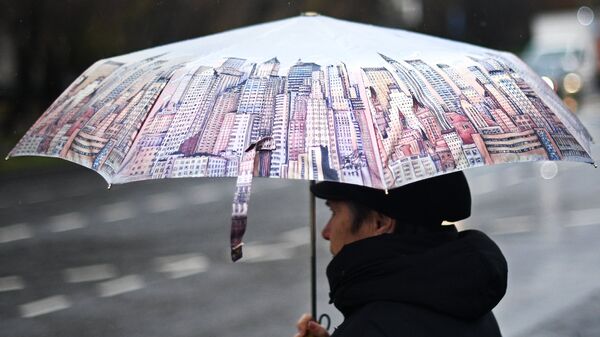 Женщина под зонтом во время дождя