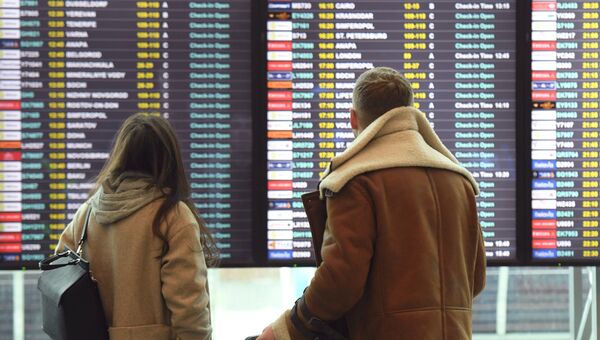 Пассажиры смотрят информационное табло в аэропорту Домодедово