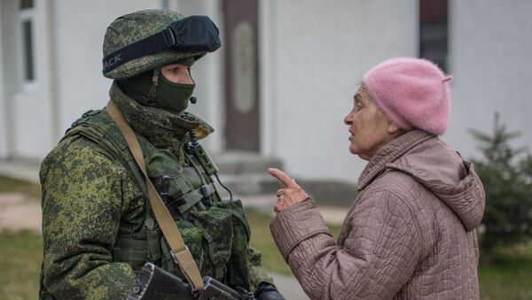 Местная жительница разговаривает с военнослужащим в селе Перевальное недалеко от Симферополя.