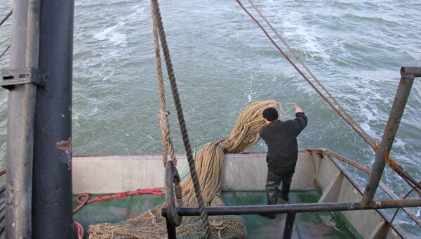 Моряк сейнера забрасывает трал в Азовское море. Архивное фото