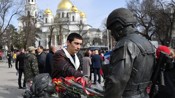 Мужчина оставляет цветы у памятника Вежливым людям во время мероприятий, посвященных 5-й годовщине Общекрымского референдума 2014 года и воссоединения Крыма с Россией, в сквере Республики в Симферополе