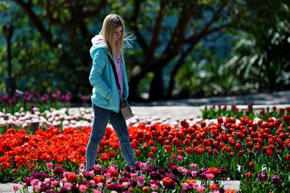 Девушка любуется цветами в Никитском ботаническом саду в Крыму