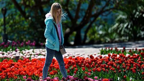 Девушка любуется цветами в Никитском ботаническом саду в Крыму
