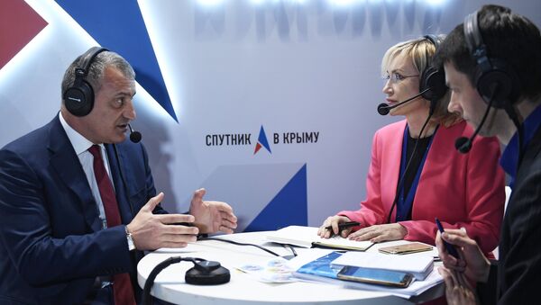 Президент Республики Южная Осетия Анатолий Бибилов (слева) дает интервью на стенде Спутник в Крыму во время Ялтинского международного экономического форума