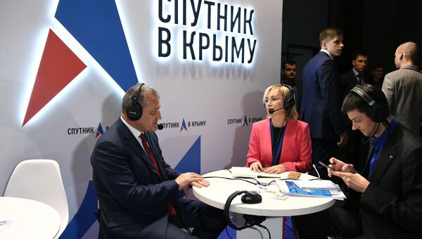 Президент Республики Южная Осетия Анатолий Бибилов (слева) дает интервью на стенде Спутник в Крыму во время Ялтинского международного экономического форума