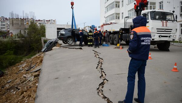 Сотрудники МЧС работают на месте обвала парковки во дворе многоэтажного дома в Севастополе