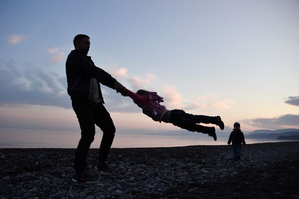 Отец играет с детьми в поселке Морское в Крыму