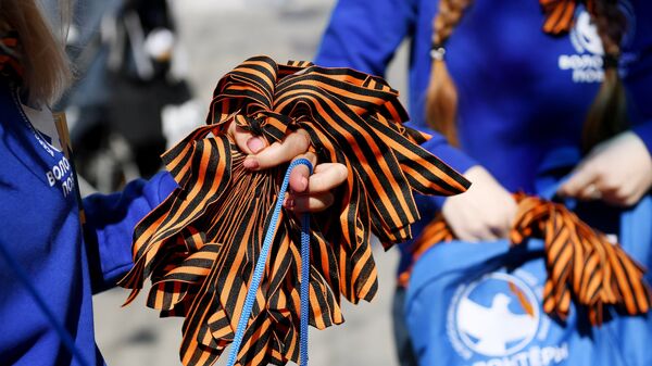 Волонтеры раздают георгиевские ленточки на Никольской улице в Москве в рамках ежегодной акции Георгиевская ленточка, посвященной 74-й годовщине Победы в Великой Отечественной войне