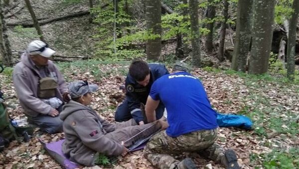 Спасатели оказывают помощь пострадавшему туристу в крымских горах