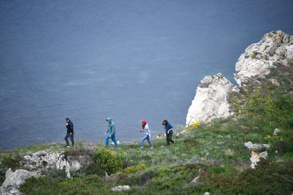 Туристы идут по Джангульскому оползневому побережью в поселке Оленевка в Крыму