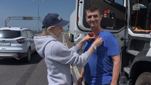 Волонтеры на стационарных постах ДПС со стороны Керчи и Тамани перед въездом на Крымский мост раздали водителям георгиевские ленты