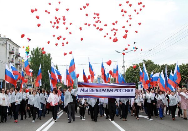Участники шествия Лента времени с плакатом Мы выбираем Россию во время торжественных мероприятий, посвященных Дню Донецкой народной республики Участники шествия Лента времени с плакатом Мы выбираем Россию во время торжественных мероприятий, посвященных Дню Донецкой народной республики