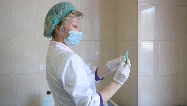 Медицинский работник производит вакцинацию от кори
