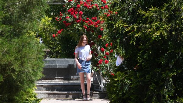 Девушка позирует возле фонтана в Ботаническом саду в Симферополе