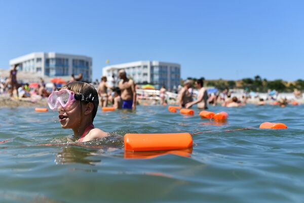 Отдыхающие купаются в Черном море возле пляжа Солдатский в Севастополе в Крыму