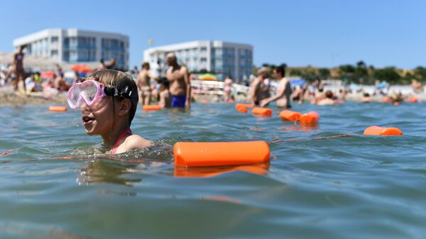 Отдыхающие купаются в Черном море возле пляжа Солдатский в Севастополе в Крыму