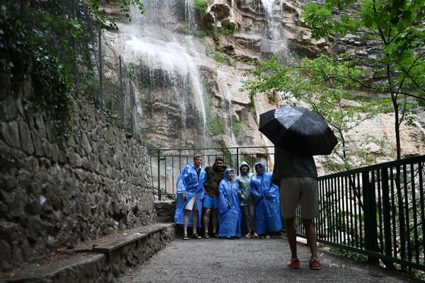 Группа туристов фотографируется на водопаде Учан-Су в окрестностях Ялты в Крыму