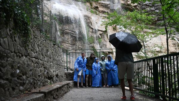 Группа туристов фотографируется на водопаде Учан-Су в окрестностях Ялты в Крыму