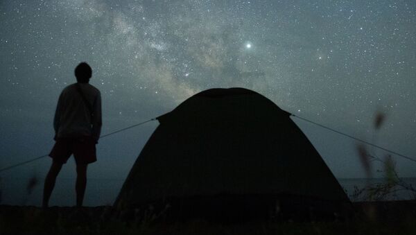 Мужчина наблюдает за звездным небом на берегу Черного моря возле поселка Морское в Крыму